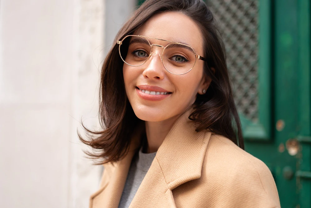 eyeglasses-vs-contact-lens-prescriptions Young woman wearing gold frame glasses outside