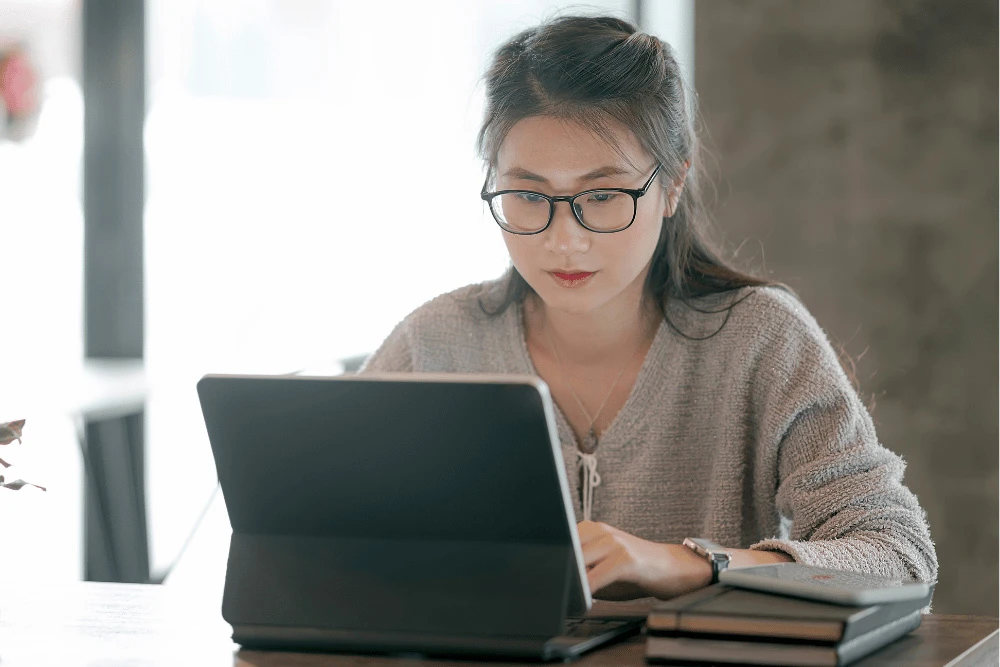 young woman with glasses using a tablet computer